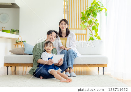 Young family living room tablet Young family living room tablet 128711652