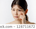 Young woman worried about eye problems (white background) 128711672