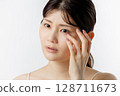Young woman worried about eye problems (white background) 128711673