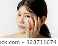 Young woman worried about eye problems (white background) 128711674