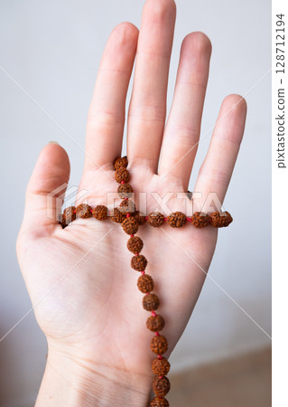 Japamala on the hand. Prayer beads. Religious equipment Japamala on the hand. Prayer beads. Religious equipment 128712194
