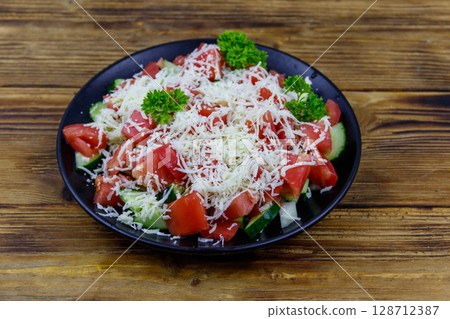 Traditional Bulgarian Shopska salad on wooden table Traditional Bulgarian Shopska salad on wooden table 128712387