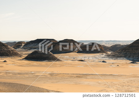 Ash-covered hills in Egypt's Black Desert under a clear sky, scenic and remote landscape. Volcanic	 128712501