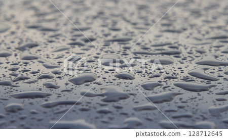 Raindrops on blue car roof - selective focus surface texture Raindrops on blue car roof - selective focus surface texture 128712645