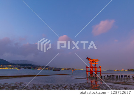 The great torii gate of Itsukushima Shrine at dusk and the seaside scenery at low tide (Miyajima, Hiroshima Prefecture) 128712657