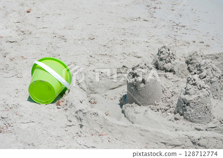 Children's sand play molds at the beach. A symbol of childhood fun and summer vacations by the sea Children's sand play molds at the beach. A symbol of childhood fun and summer vacations by the sea 128712774