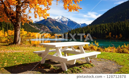 An autumn mountain landscape with a serene lake, a lone bench, and reflections of the scenic sky An autumn mountain landscape with a serene lake, a lone bench, and reflections of the scenic sky 128712878