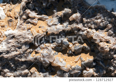 Close-up of a natural quartz formation inside a cave. The detailed crystal structure and layers of the mineral Close-up of a natural quartz formation inside a cave. The detailed crystal structure and layers of the mineral 128712927
