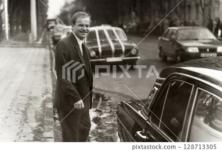 Vintage portrait of young man groom before wedding near car decorated with wedding decorations. 128713305
