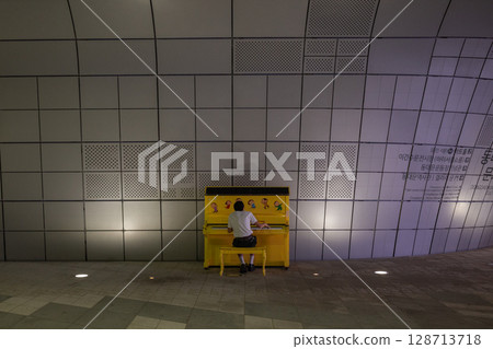 [South Korea] Back view of a man playing a yellow piano in a square in Seoul 128713718