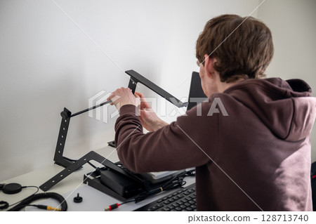 person adjusting ergonomic metal laptop stand on white desk in home office person adjusting ergonomic metal laptop stand on white desk in home office 128713740