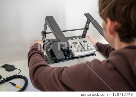 person adjusting ergonomic metal laptop stand on white desk in home office person adjusting ergonomic metal laptop stand on white desk in home office 128713749