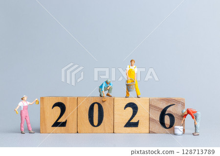 Tiny figurine workers painting and assembling wooden blocks to form the number 2026 Tiny figurine workers painting and assembling wooden blocks to form the number 2026 128713789