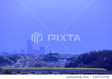 Doctor Yellow running with the buildings of Minato Mirai in the evening skyline in the background 128714146