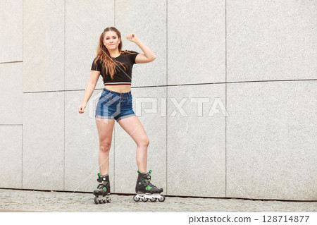 Young woman riding roller skates Young woman riding roller skates 128714877
