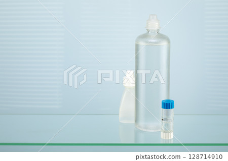 Night contact lenses. Ophthalmology composition with containers with night contact lenses, moisturizing eye drops and clean solution. Advertising contact lenses for vision. Optical store. Copy space Night contact lenses. Ophthalmology composition with containers with night contact lenses, moisturizing eye drops and clean solution. Advertising contact lenses for vision. Optical store. Copy space 128714910