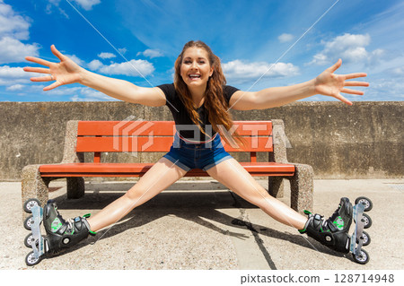 Joyful girl wearing roller skates 128714948
