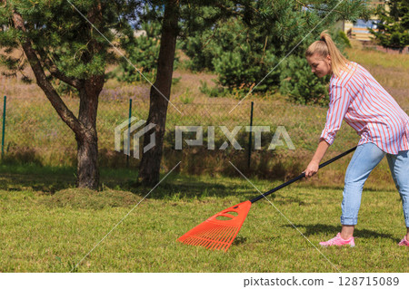 Woman raking leaves Woman raking leaves 128715089