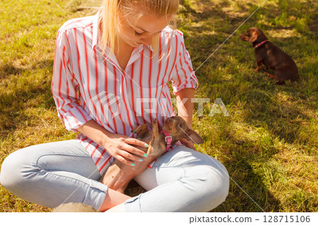 Woman playing pinscher ratter dog outside Woman playing pinscher ratter dog outside 128715106