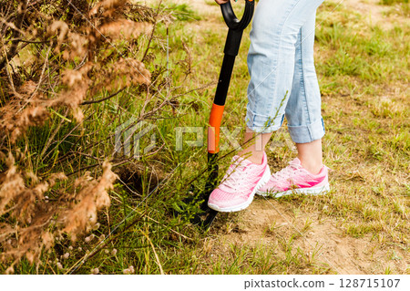 Woman digging hole in garden 128715107