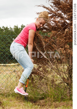 Woman digging hole in garden 128715108