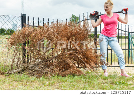 Woman digging hole in garden 128715117
