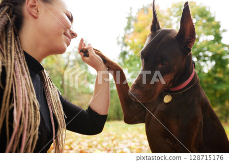 Woman shares a special bond with her dog in a park 128715176