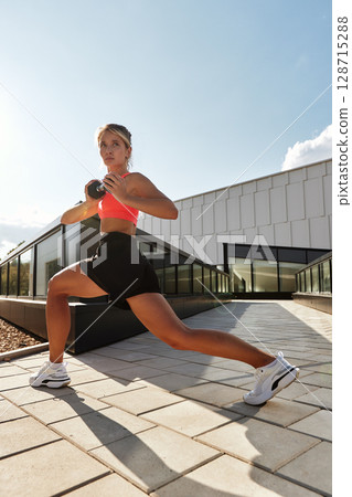 Athletic woman stretching outdoors under bright sunlight in sportswear Athletic woman stretching outdoors under bright sunlight in sportswear 128715288