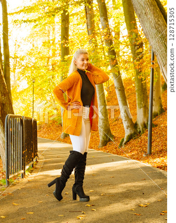 Woman walking in autumn park 128715305