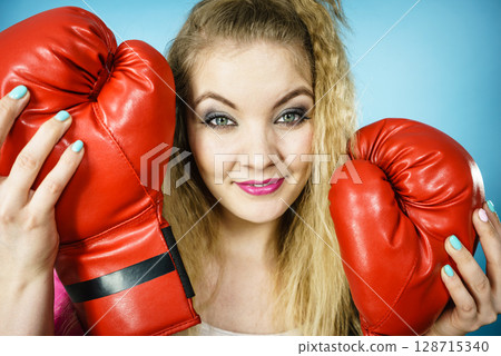 Funny girl with red gloves playing sports boxing 128715340