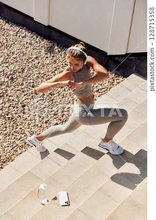 Active female exercising outdoors in a modern fitness and health lifestyle Active female exercising outdoors in a modern fitness and health lifestyle 128715358