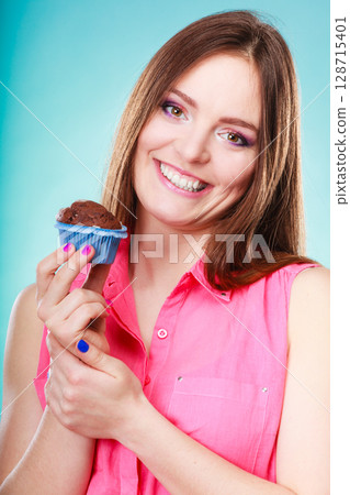 Smiling woman holds chocolate cake in hand Smiling woman holds chocolate cake in hand 128715401