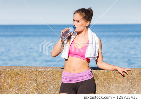 Woman drinking water after sport gym outdoor Woman drinking water after sport gym outdoor 128715415