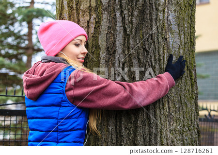 Woman wearing sportswear hugging tree Woman wearing sportswear hugging tree 128716261