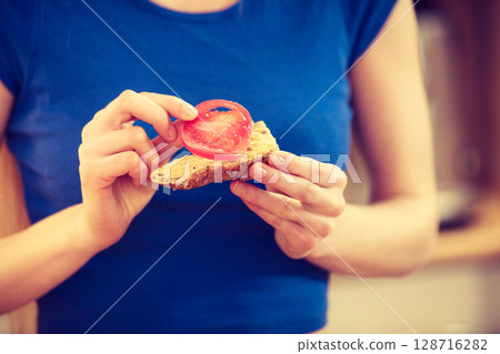 Woman preparing healthy breakfast making sandwich Woman preparing healthy breakfast making sandwich 128716282