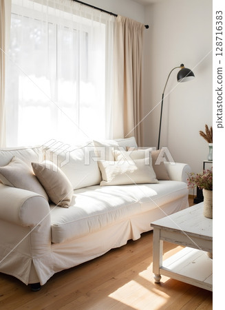 Cozy Minimalist Living Room with White Sofa and Natural Light Filtering Through sheer Curtains 128716383