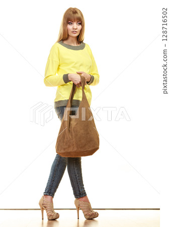 woman holds brown fringe handbag woman holds brown fringe handbag 128716502