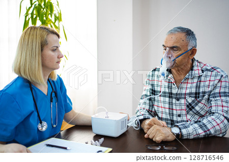 Elderly man receives respiratory treatment with care 128716546
