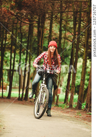 girl relaxing in autumnal park with bicycle. 128716707