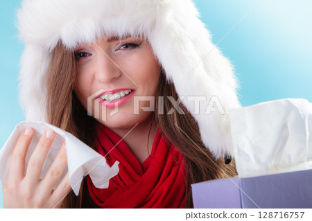 sick woman with fever sneezing in tissue. Winter time. sick woman with fever sneezing in tissue. Winter time. 128716757