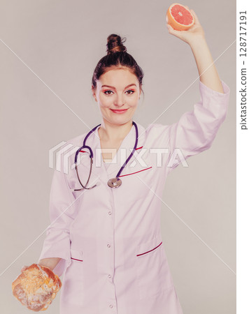 Dietitian with sweet roll bun and grapefruit. Dietitian with sweet roll bun and grapefruit. 128717191