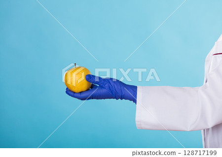 Nutritionist holding apple fruit in her hand Nutritionist holding apple fruit in her hand 128717199