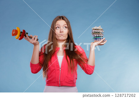 Woman with diet weight loss pills and vegetables. 128717202