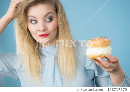 Funny woman holds cream puff cake 128717379