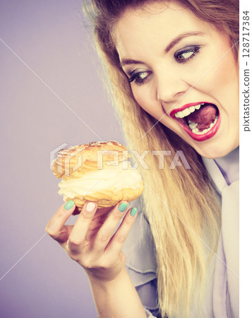 Funny woman holds cream puff cake 128717384