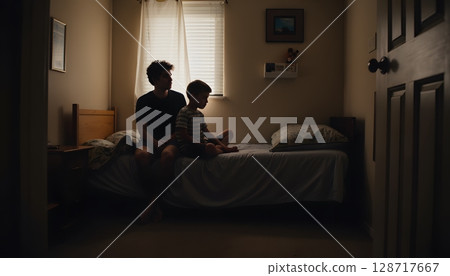 Tender Moments Between Father and Child in a Cozy Bedroom Setting with Soft Natural Light 128717667