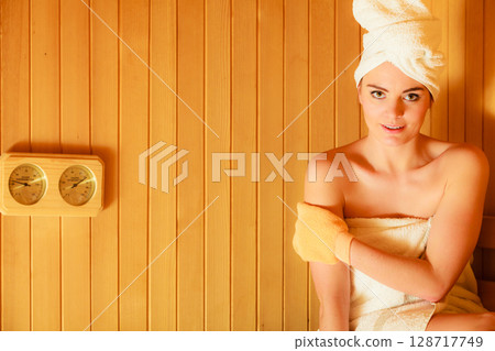 woman relaxing in wooden sauna room 128717749