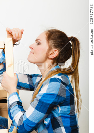 Woman assembling wooden furniture. DIY. Woman assembling wooden furniture. DIY. 128717788