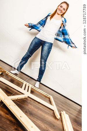 Happy woman assembling wood furniture. DIY. Happy woman assembling wood furniture. DIY. 128717789