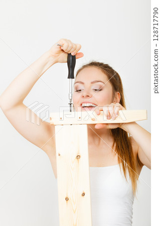 Woman assembling wooden furniture. DIY. Woman assembling wooden furniture. DIY. 128717790